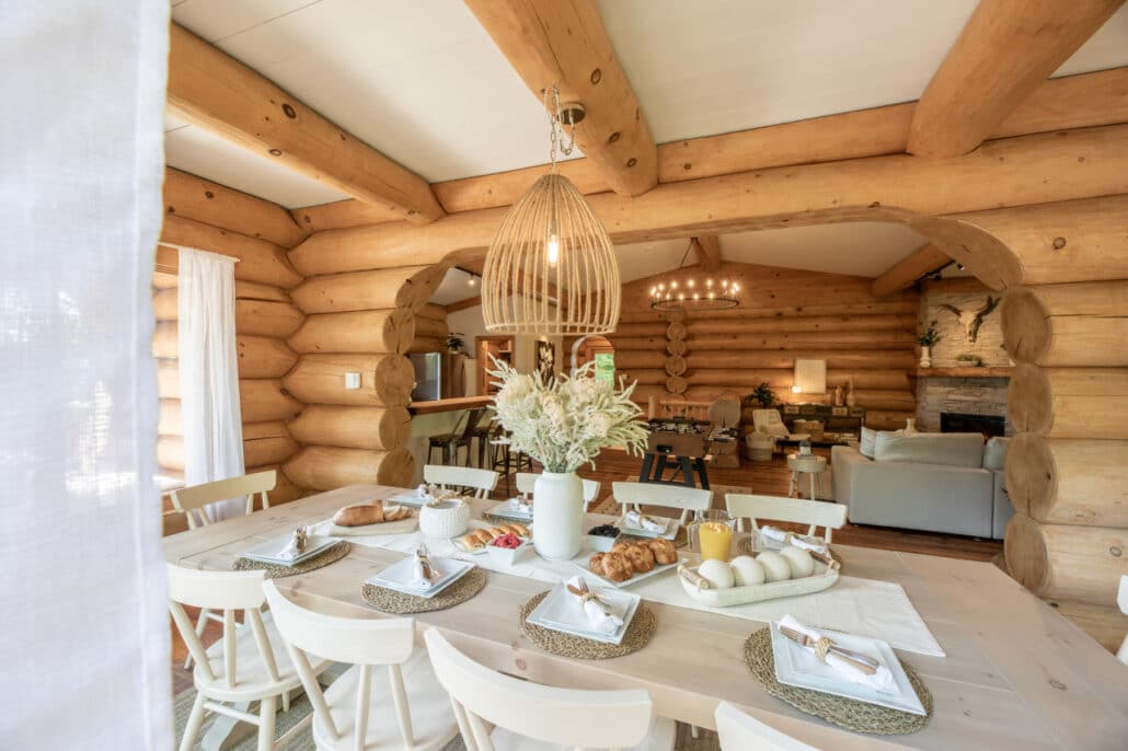 Salle à manger d'un chalet en bois rond avec lustre