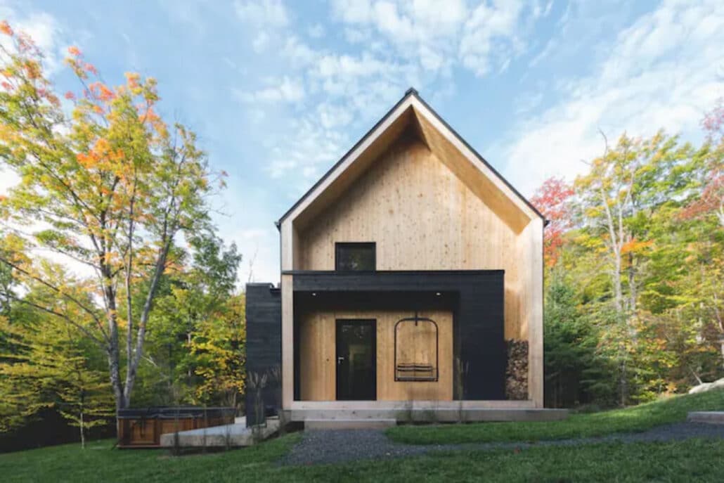 Extérieur d'un chalet en A moderne, bois et noir, en automne