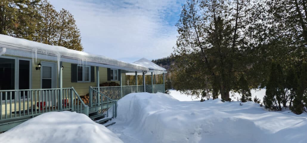 Extérieur allongé d'un chalet en hiver, sous la neige